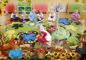 Dzieci siedzą na dywanie. Chłopiec układa jabłka.